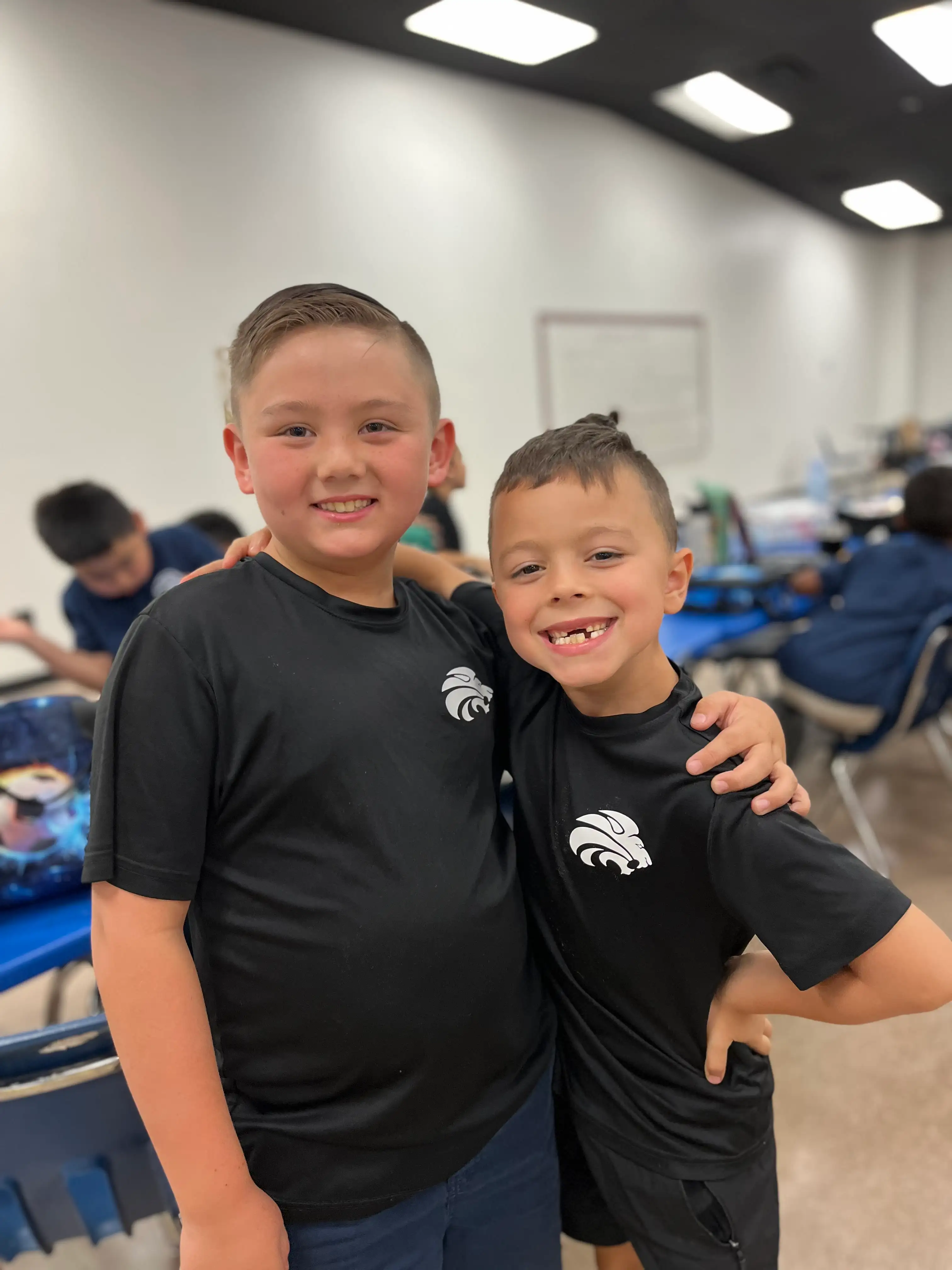 Two smiling Awaken students in Lions shirts