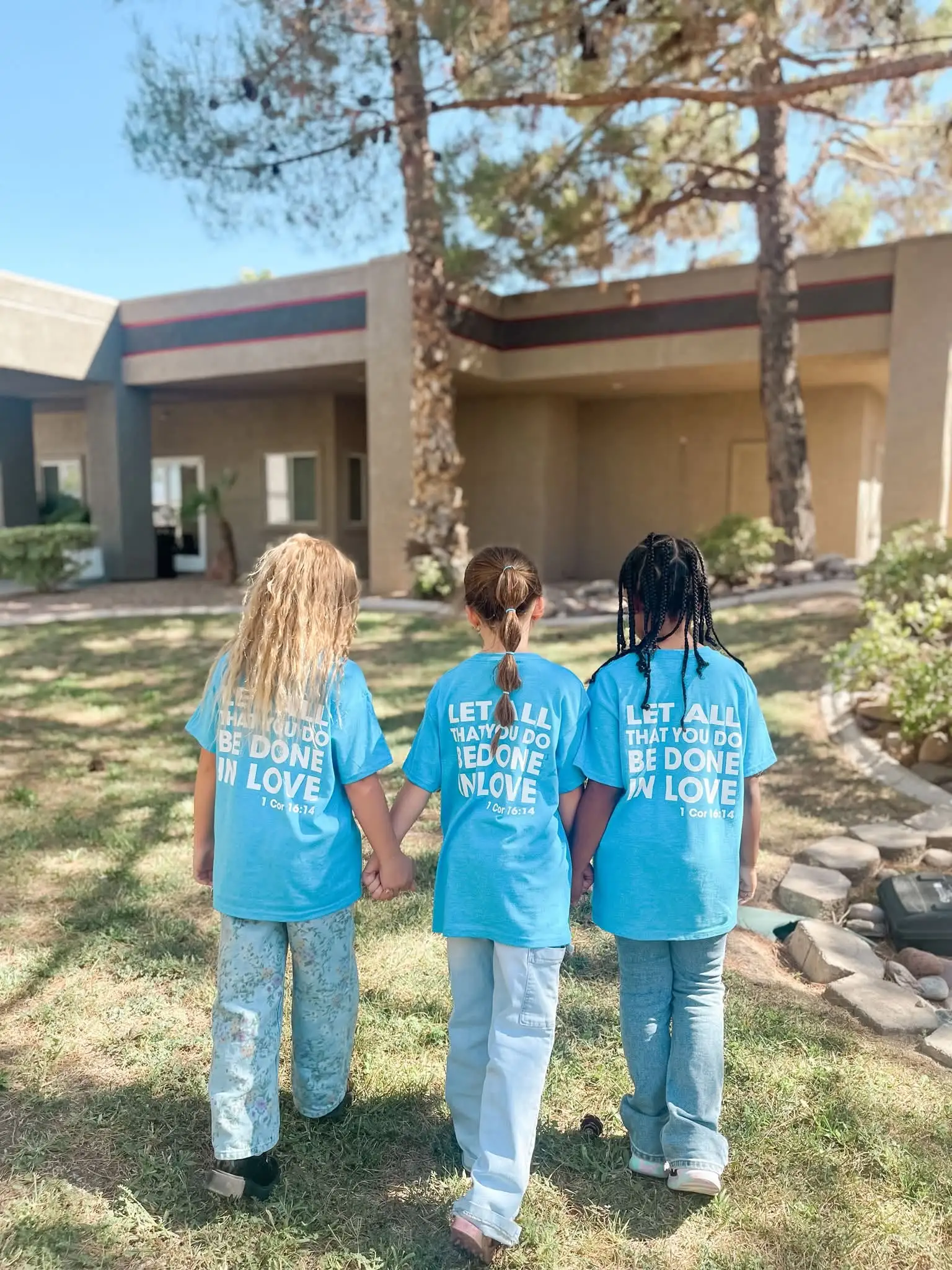 Three Awaken students walking hand in hand on campus